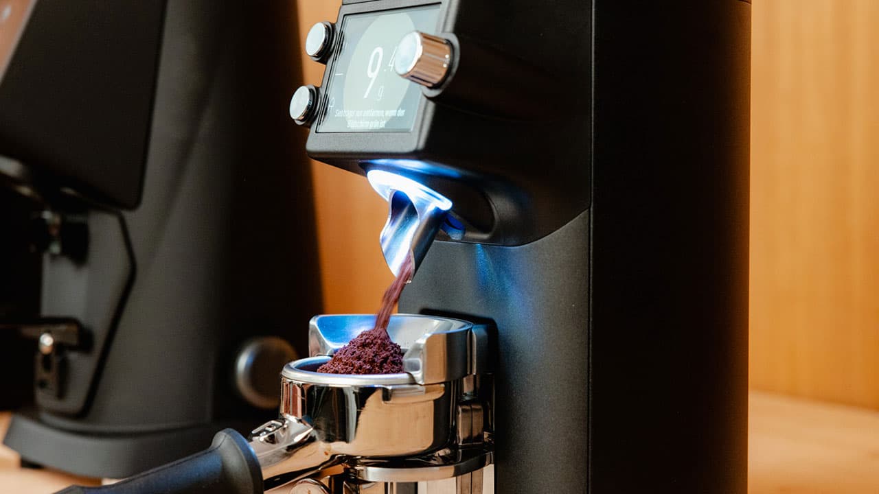 Mahlkönig E64 WS Mahlwerk dosiert frisch gemahlenes Kaffeepulver in Siebträger, beleuchtete Auslassöffnung