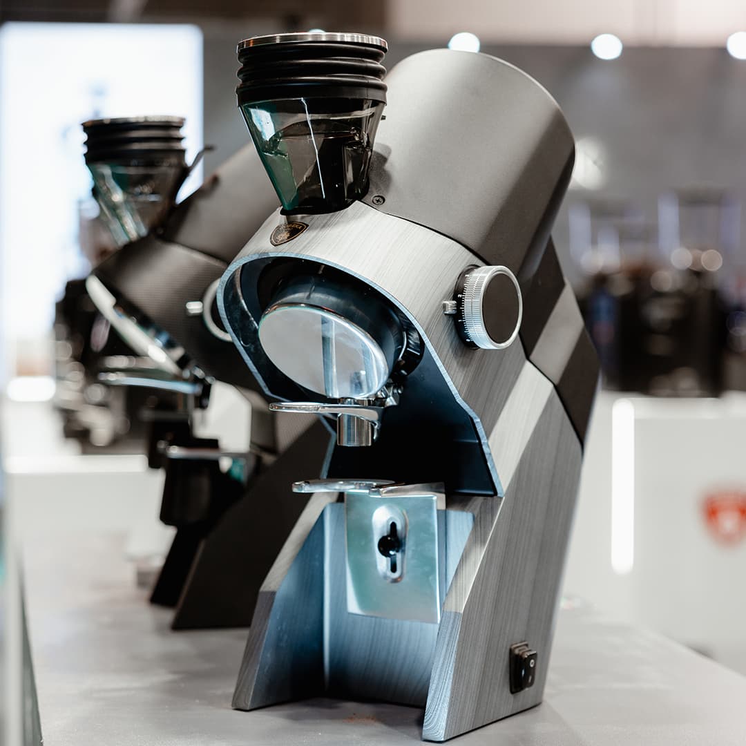 Eureka Espressomühle in modernem Design auf Messestand, Metallgehäuse, Bohnenbehälter und Dosiergriff sichtbar