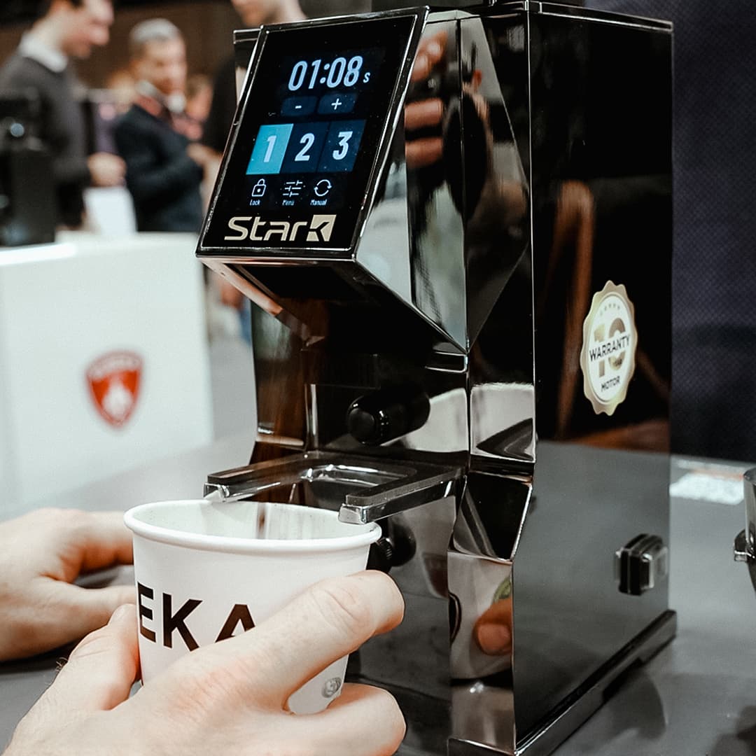 Eureka Stark Kaffeemühle/Grinder am Messestand, Touchdisplay mit Timer, Papierbecher wird unter Auslauf gehalten