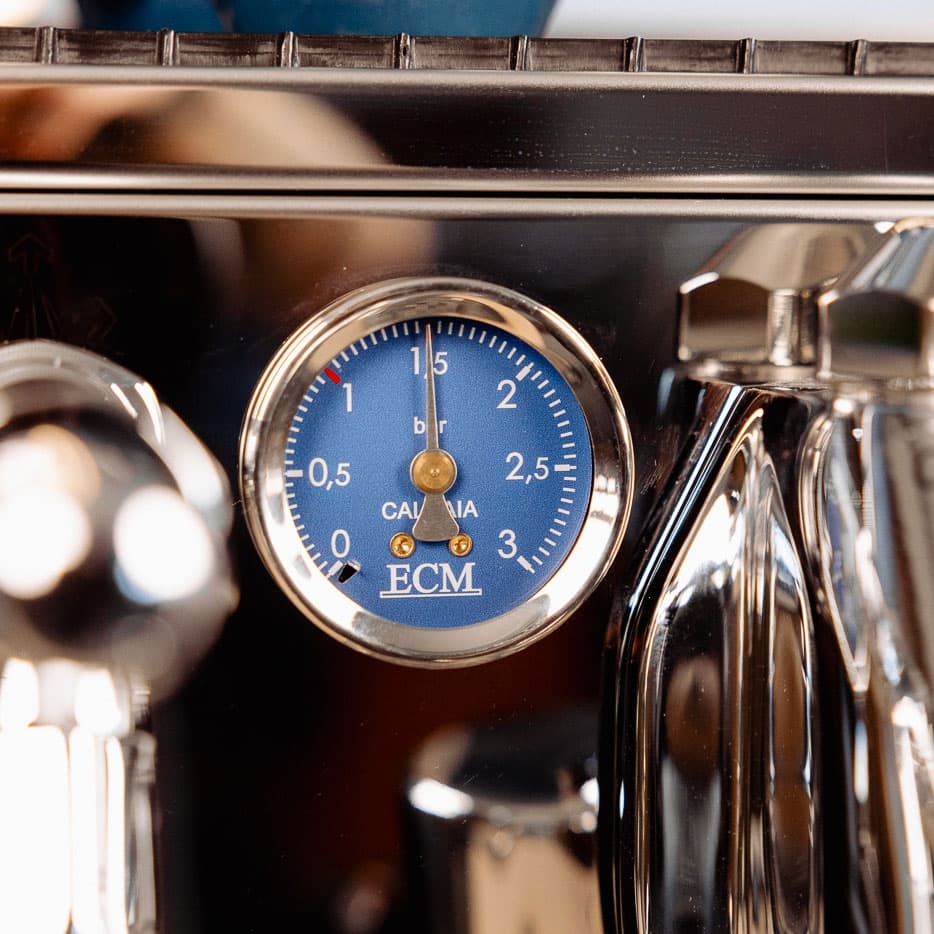 Blauer Druckmesser (Manometer) mit ECM-Logo an glänzender ECM Technika Espressomaschine, zeigt rund 1,5 bar